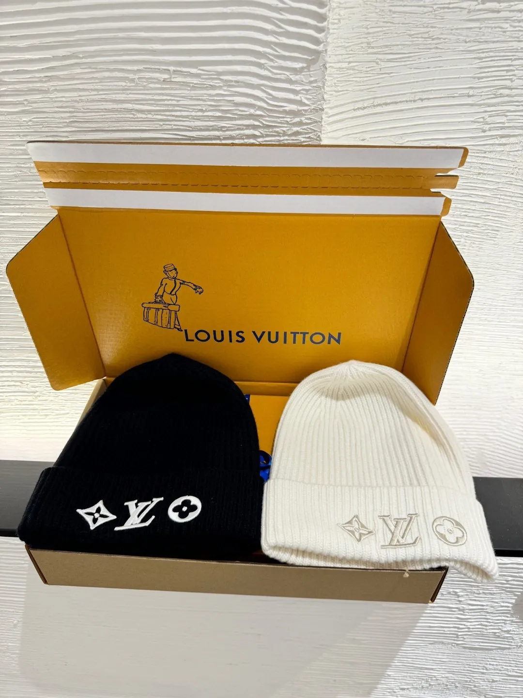 LOUIS VUITTON new embroidered wool cold hat ●Original version: 3800 purchase and development ●Item number: 1681973-A45 ●Fabric: wool blended fabric ●Technology: embroidery production ●Color: white/black ●Version: fitted version ●Description: This is LV The 2025 autumn and winter series logo embroidered knitted cold hat is made of 100% Italian virgin wool, woven with a 30-needle dense weaving process. The yarn twist reaches 600 twists/meter, which has both warmth and stiffness. The main body of the hat has a vertical grooved texture, which is elastically wrapped through fixed-spacing stitching techniques. The front logo of the hat uses three-dimensional appliqué technology, and the Monogram elements (quatrefoil, LV letters) are sewn with high-density embroidery threads of the same color. The edges are overlocked to prevent fuzzing and threading; the top of the hat is made of double-layer ribbing, which is durable and elastic and fits the ears. The finished product is shaped by high-temperature steam, and the three-dimensional shape of the hat is not easily deformed. The post-finishing process includes anti-static treatment, making it more comfortable for daily wear. The lining of the packaging is printed with the brand's classic "luggage maker" pattern, continuing the brand's retro luxury tone. The overall wiring is straight and delicate, the fabric is comfortable and soft, and the color is consistent without color difference. It can be matched with the same style to create a fashionable look and control various occasions. Customized accessories, complete with three standards, same style for men and women!